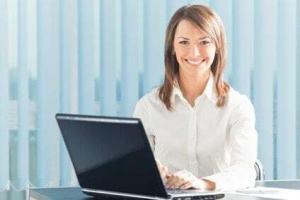 Happy smiling businesswoman with laptop at office