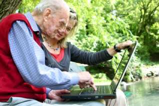 Old man and young women using computer