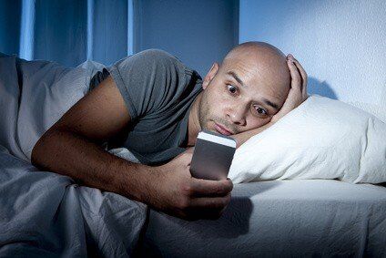 Man checking email in bed