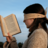 How to deliberately avoid vital information Woman trying to read book whilst blindfolded