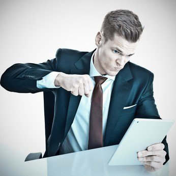 Man punching tablet in anger at receiving rude emails