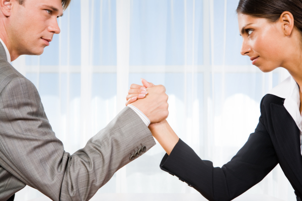 People in business suits arm wrestling